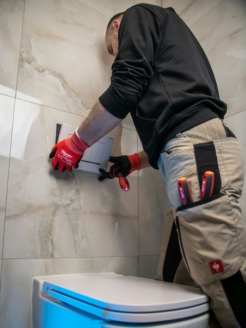 Plombier débouchant un WC